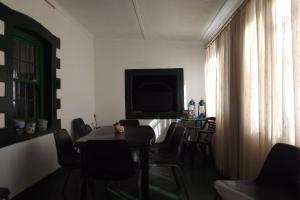 a dining room with a table and chairs and a television at Verbe Farm Accommodation in Kamieskroon