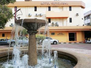 una fuente de agua frente a un edificio en SkyGlobal Hotel en Labuan