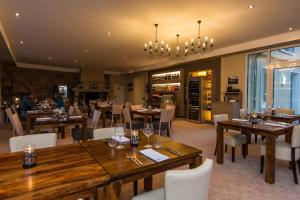 een restaurant met houten tafels en stoelen en een kroonluchter bij Parkhotel Cochem in Cochem