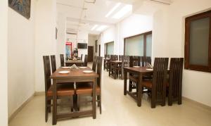 uma fila de mesas e cadeiras numa sala de jantar em Treebo Trend Dee Intercontinental Amritsar em Amritsar