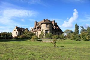an old house in a field with a green field at Le Logis d'Arniere in Saint Cyr-sous-Dourdan