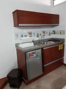 a small kitchen with a sink and a refrigerator at Apartamentos Freddy's Tours in Santa Marta