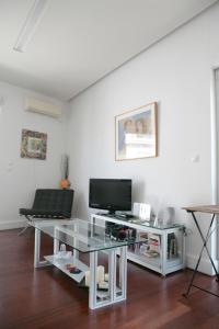een woonkamer met een tv en een glazen tafel bij Mind-blowing Acropolis View Apt in Athene