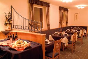 ein Esszimmer mit Tischen und Flaschen Wein in der Unterkunft Hotel Central in Welschnofen