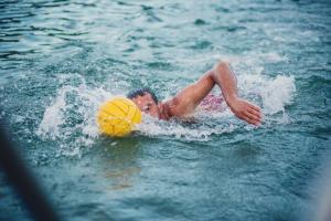 a man swimming in the water with a ball at Green Resort Glamping in Radlje ob Dravi