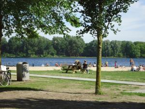 a group of people sitting at a picnic table on the beach at B&B Sloterpark in Amsterdam