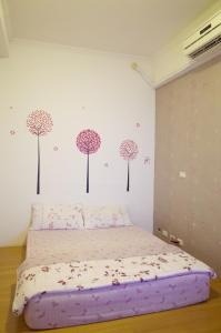 um quarto com uma cama com flores na parede em Dong Gang Li Yuan Homestay em Donggang
