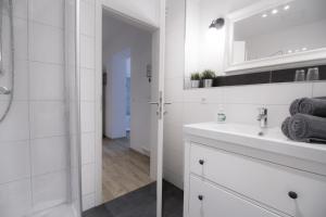 a white bathroom with a sink and a mirror at Ferienwohnungen EULE in Lutherstadt Wittenberg +46 photos