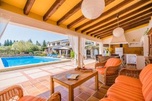 a living room with a table and a swimming pool at Can Giro in Pollença