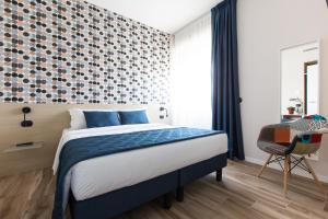 1 dormitorio con 1 cama con manta azul y pared en Aparthotel Isola en Milán