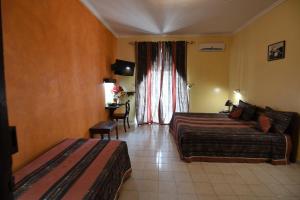 a hotel room with two beds and a window at Hotel de La Poste in Saint-Louis