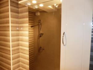 a shower stall in a bathroom with wooden tiles at Apartments Pavlić in Saplunara