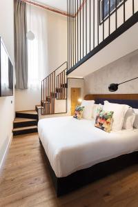 a bedroom with a large white bed and a staircase at One Shot Tabakalera House in Donostia-San Sebastián