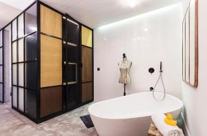 a bathroom with a white tub and a dressing room at One Shot Tabakalera House in Donostia-San Sebastián