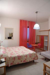una camera con letto, tavolo e sedia di Hotel Il Falchetto a Pontedera