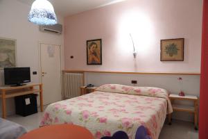 ein kleines Schlafzimmer mit einem Bett und einem TV in der Unterkunft Hotel Il Falchetto in Pontedera