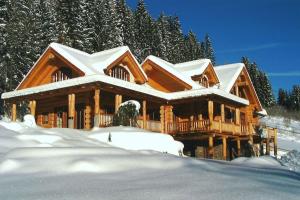 a log cabin with snow on the roof at Chalet Caprea in Bad Kleinkirchheim