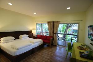 a hotel room with a bed and a red chair at Palita Lodge - SHA Plus in Haad Rin +37 photos