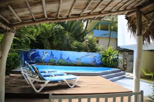 una piscina con poltrona e parete blu di Casa Brisa Mar Hotel a Las Terrenas