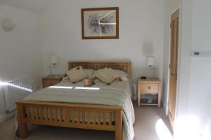 a bedroom with a bed with two teddy bears on it at Pear Tree House Studio in Ely