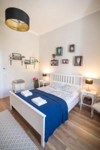 エゲルにあるBródy Apartmanのベッドルーム1室(青と白のベッド1台、テーブル2台付)