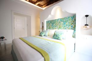 a bedroom with a large white bed with a blue and green wall at I Soffitti Dimora Esclusiva in Tropea