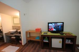 a living room with a television on a table at Palita Lodge - SHA Plus in Haad Rin