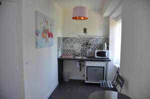 a small kitchen with a table and a microwave at Le Florentin in Florentin-la-Capelle