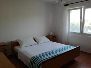 1 dormitorio con 1 cama con sábanas blancas y ventana en Apartment Bonaca en Lun