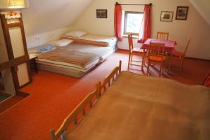 a bedroom with two beds and a table and chairs at Ferienhaus Ahornweg in Bad Kleinkirchheim