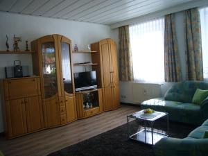 uma sala de estar com um sofá e uma televisão em Ferienwohnung im alten Schulhaus - keine Monteure em Plech