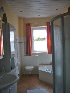 uma casa de banho com uma banheira, um WC e uma janela. em Ferienwohnung im alten Schulhaus - keine Monteure em Plech