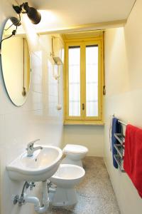 a bathroom with a sink and a toilet and a mirror at Appartamento Conte Rosso in Turin