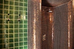 ブダペストにあるGrand Budapest Apartmentの緑のタイル張りの壁のバスルーム(シャワー付)