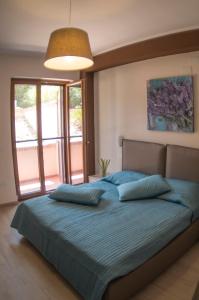 una camera da letto con un grande letto con cuscini blu di B&B Villa Gaudium a Pompei