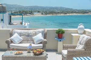 eine Terrasse mit Stühlen und einem Tisch mit Blick auf den Strand in der Unterkunft Kymata Hotel in Naxos Chora