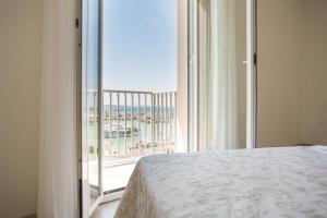 a bedroom with a bed and a view of the beach at Hotel Olympia in Gabicce Mare