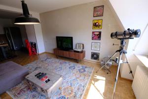 a camera in a living room with a television and a tripod at Domus Merian XII in Trier