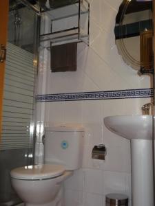 a white bathroom with a toilet and a sink at Las tercias de Curiel in Curiel de Duero