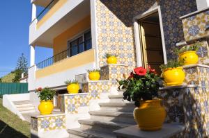 a house with yellow vases on the stairs at Casa Amarela Belém in Lisbon