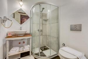 a bathroom with a shower and a toilet and a sink at Alacati Eski Ev Hotel in Alacati
