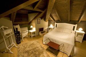 1 dormitorio con 1 cama blanca grande y 2 mesas en Complejo Turístico L'oteru, en Caleao