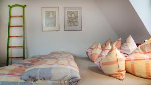 バーデン・バーデンにあるエカタリーナ アパートメンツのベッドルーム1室(ベッド2台付)が備わります。壁に2枚の写真が飾られています。