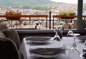 a table with wine glasses and a view of a city at Hotel Pinocchio in Pristina