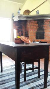 a wooden table in a room with a fireplace at Casa Serra do Lagar in Ribeiradio