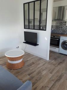 a living room with a table and a tv in a room at Appartement Côté Bassin in Andernos-les-Bains