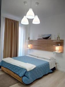a bedroom with a large bed with two pendant lights at L'AF ROOMS in Favara