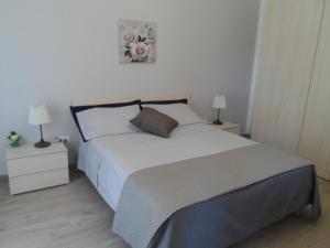 una camera da letto con un grande letto bianco con due lampade di Casa Simo a Pachino