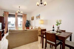 uma sala de estar com um sofá e uma mesa em Apartamento Atenea centro con garaje gratuito em Ronda