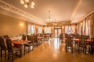 a restaurant with tables and chairs and curtains at Nemeth Camping Spa & Pool Access in Sovata